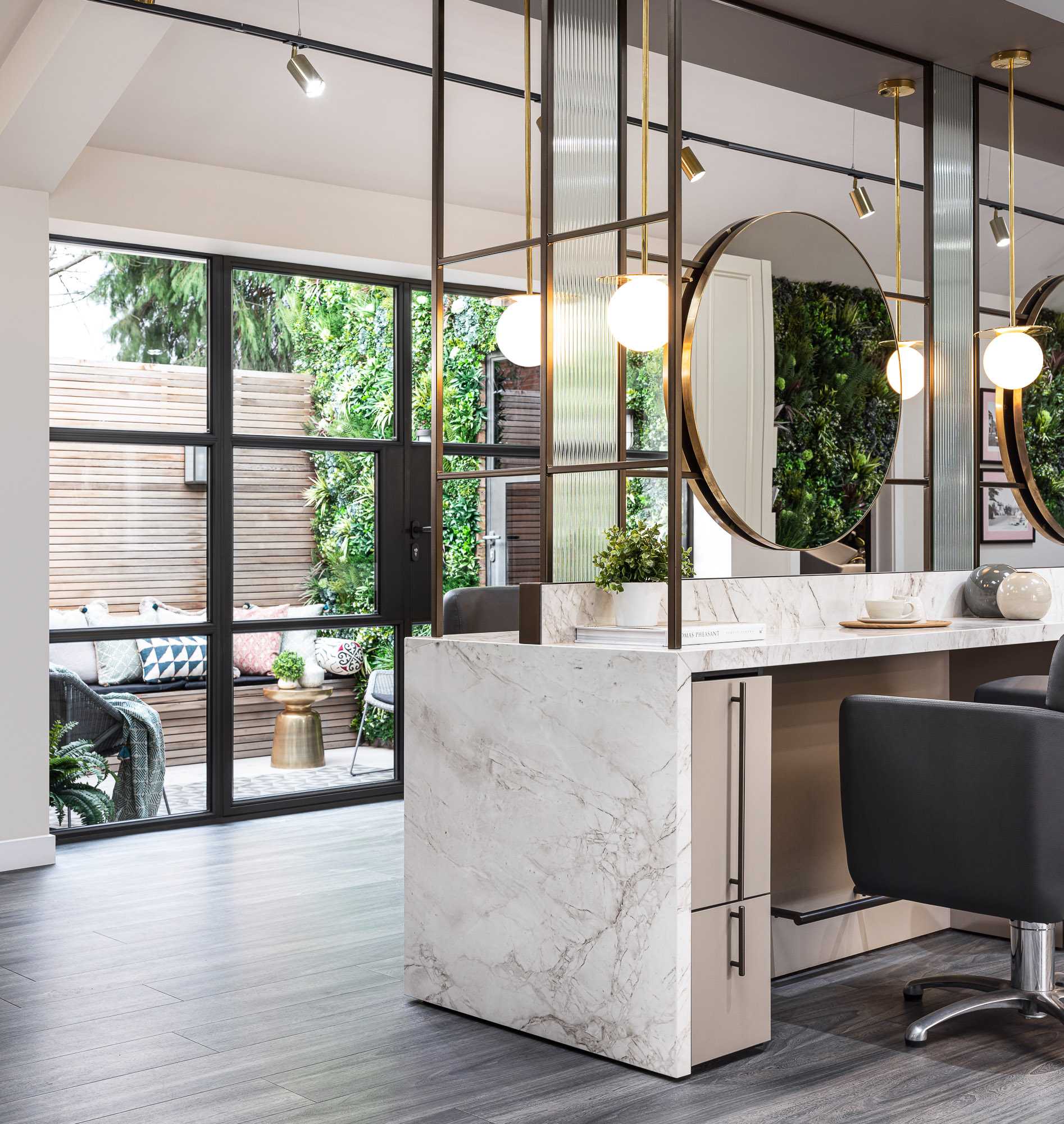 Leo Bancroft Hair Salon with crittall style doors to courtyard and marble worktops, round brass mirrors