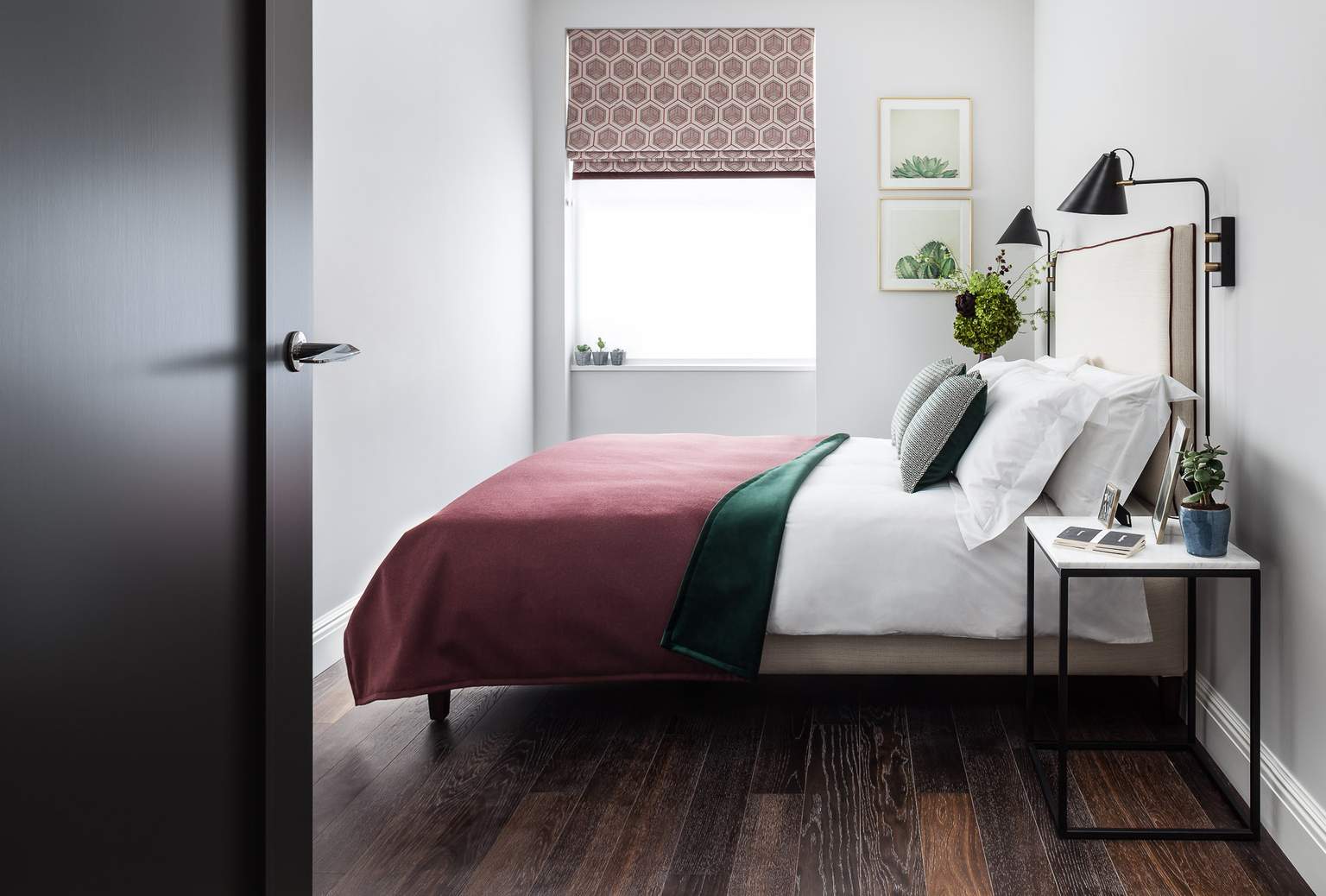 Bedroom Red with hexagonal blind, cactus prints, black metal wall lights, marble bedside tables from Gillmore space