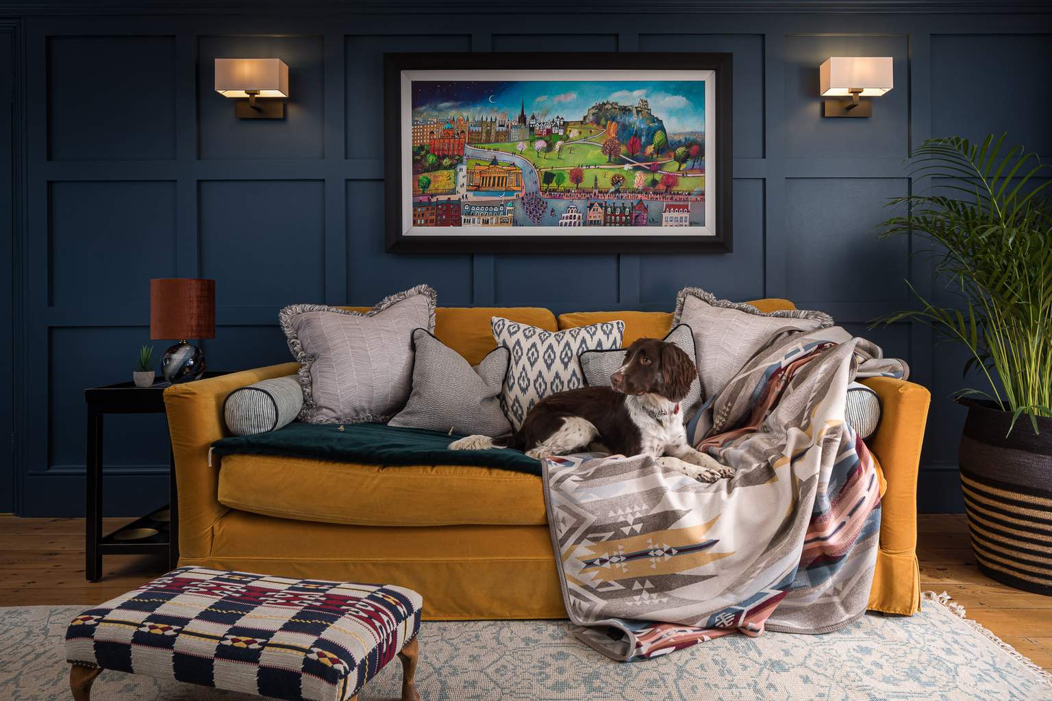 Panelled snug with yellow velvet sofa and English springer spaniel