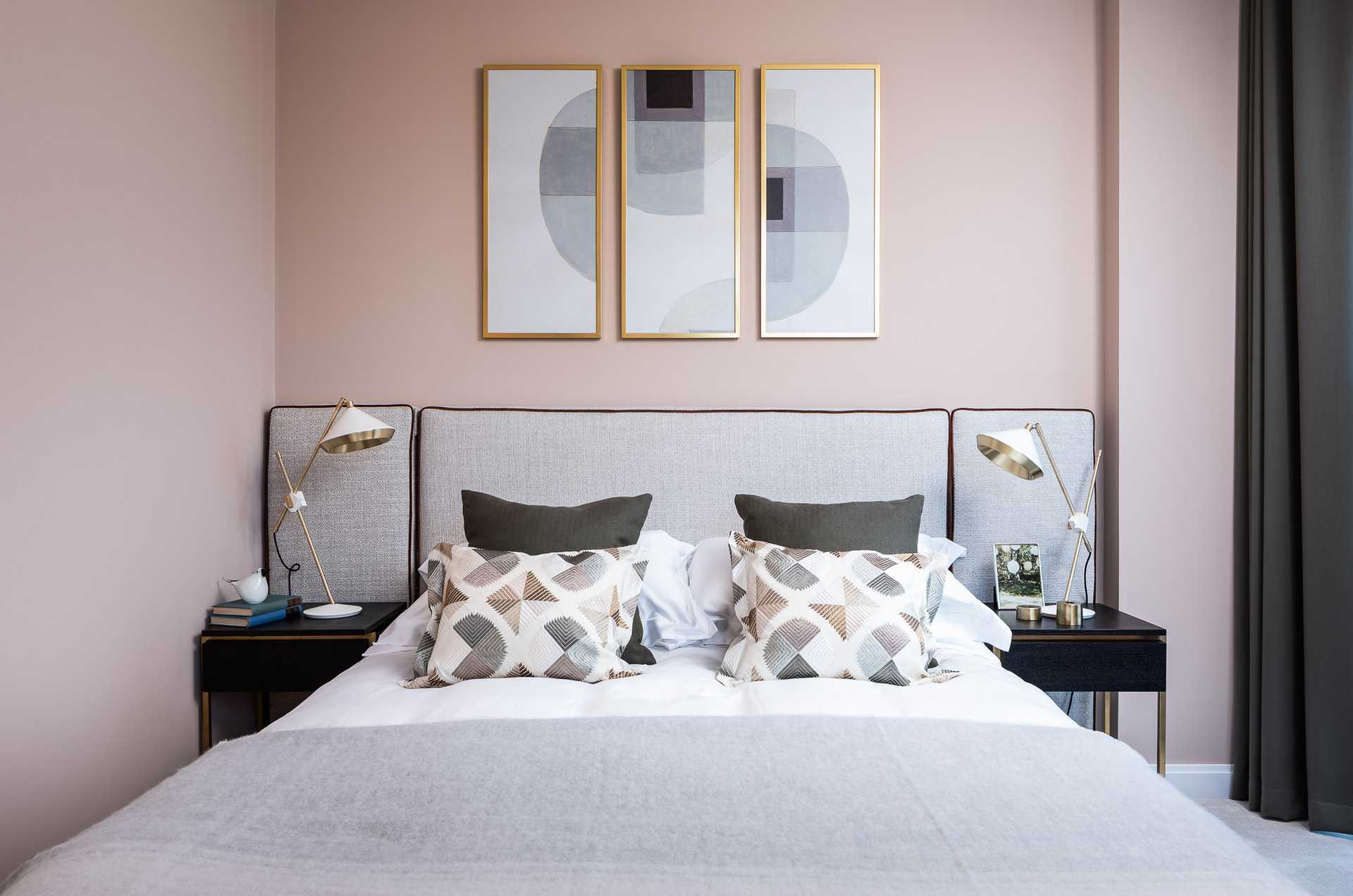 Pink bedroom with abstract art and Bert Frank table lamps. Zimmer & Rhode cushion fabric
