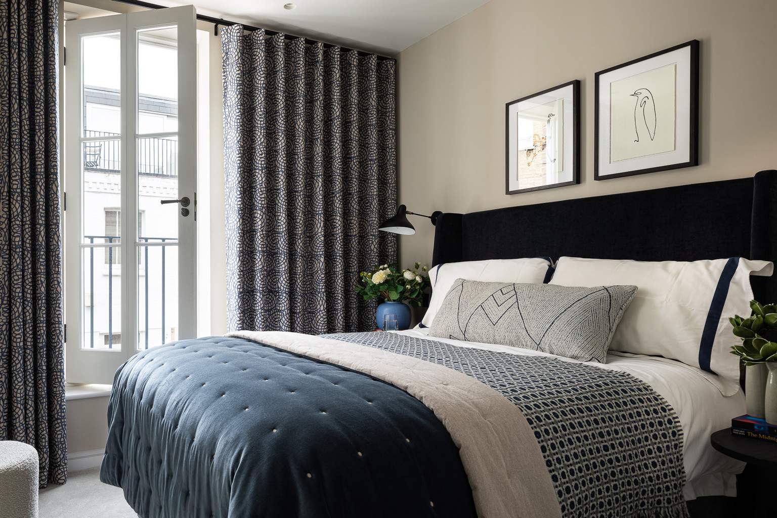 Guest bedroom with blue velvet headboard and Pierre Frey curtains